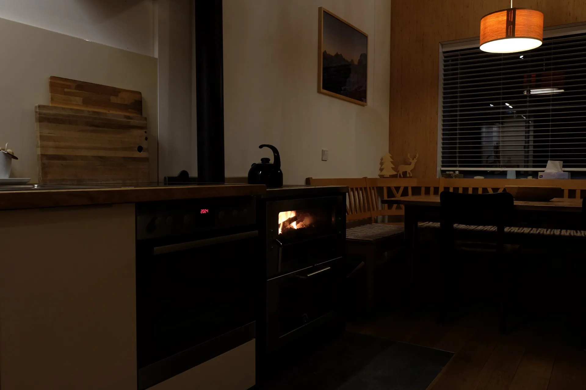 Gemütliche Küche mit brennendem Holzofen am Abend